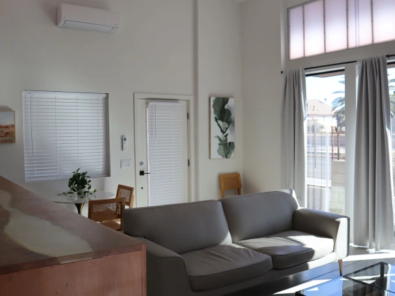 University rowhouse living room space featuring high ceilings, couch and coffee table