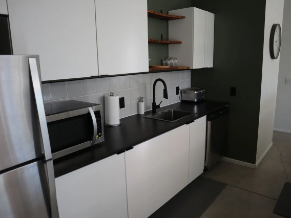 University rowhouse featuring microwave, counterspace, and stainless steel refrigerator