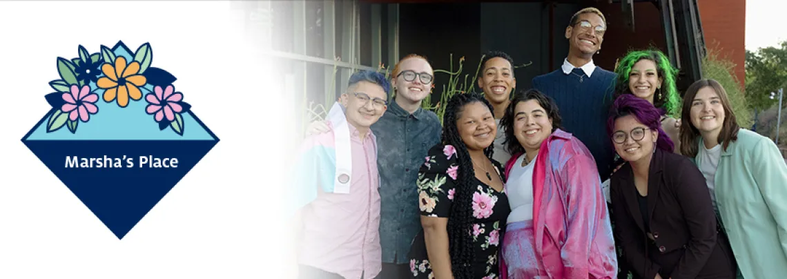 Group of Marha's Place members next to Marsha's Place flower logo.