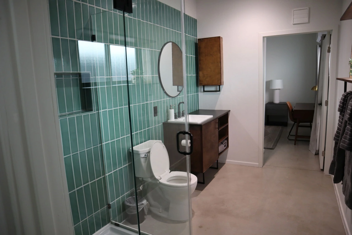 University rowhouse bathroom featuring walk-in glass shower