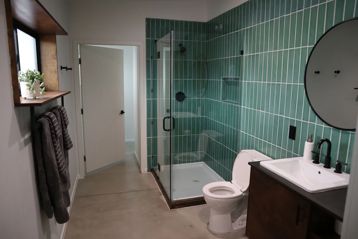 University rowhouse bathroom featuring walk-in glass shower