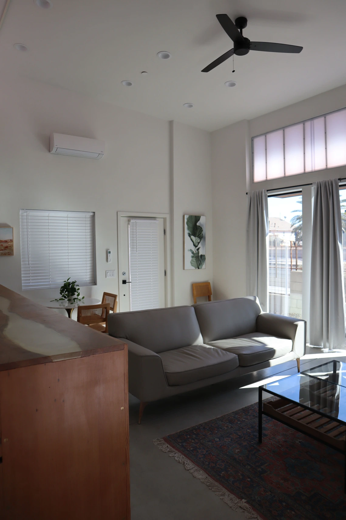 University rowhouse living room space featuring high ceilings, couch and coffee table