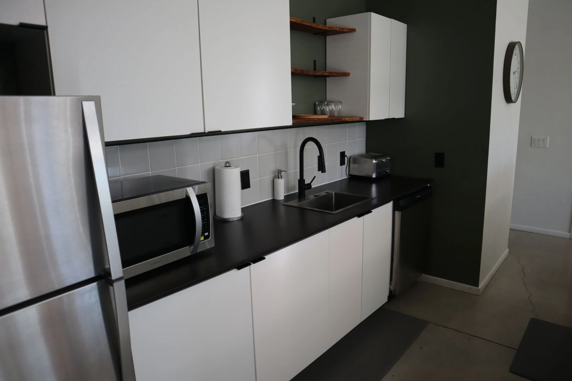 University rowhouse featuring microwave, counterspace, and stainless steel refrigerator